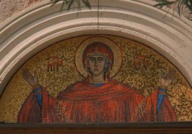 A detailed mosaic of the Virgin Mary at a church entrance, reflecting Christian art.