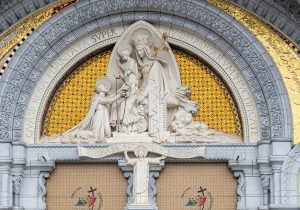 Intricate facade artwork at Basilique Notre-Dame du Rosaire in Lourdes, France.