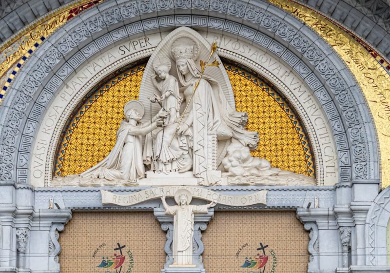 Intricate facade artwork at Basilique Notre-Dame du Rosaire in Lourdes, France.