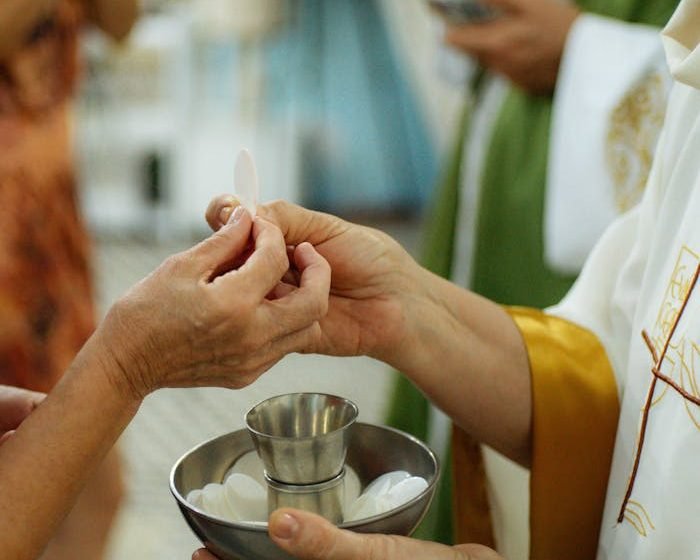 A priest gives Communion during a church service, showing the sacred rituals of Christianity.