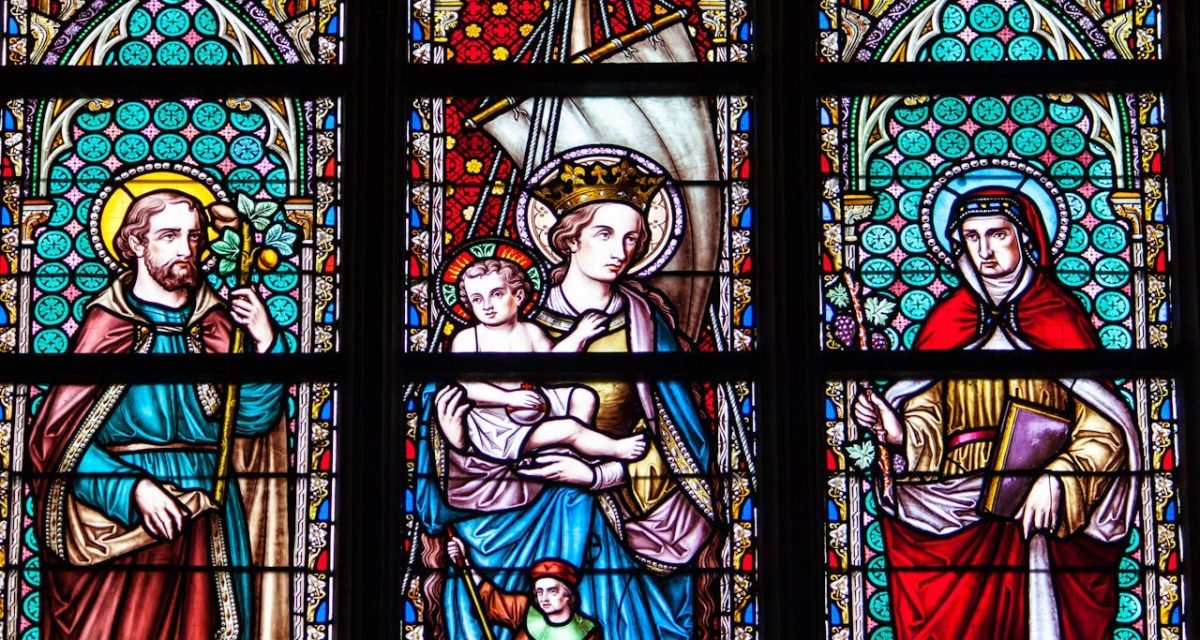 Colorful stained glass depicting saints and religious figures in a Brussels cathedral.