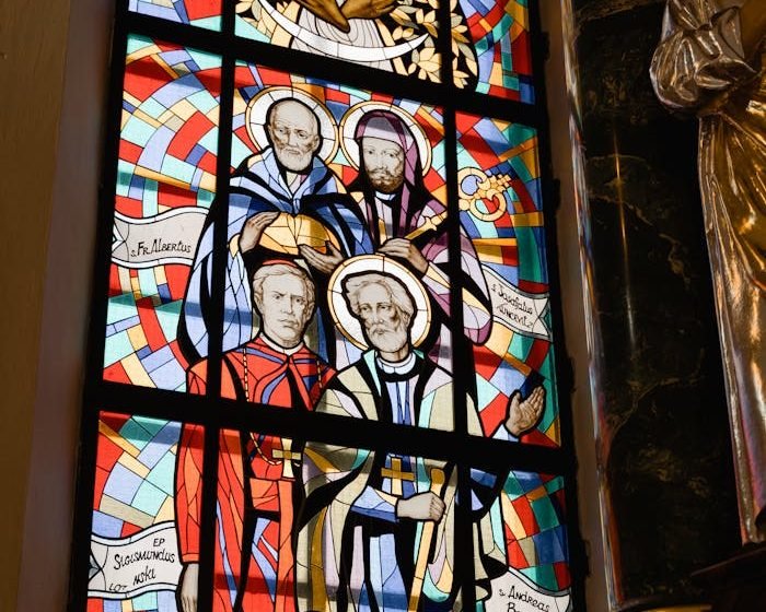Colorful stained glass depicting religious figures in a church setting.